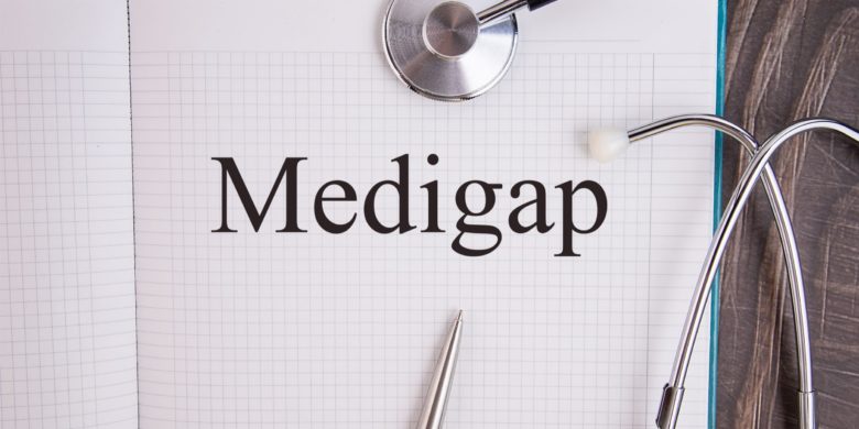 medigap (also known as medicare supplemental) written in paper that is under stethoscope and pen